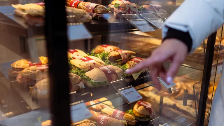 Ein finger zeigt auf eine sandwich vitrine
