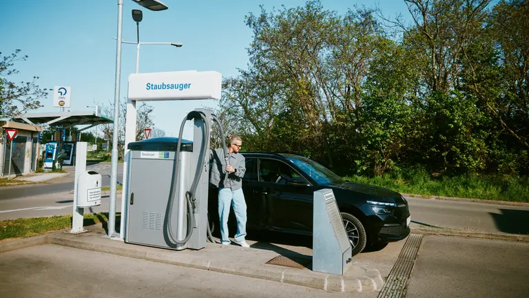 Ein Mann bei einer OMV Tankstelle saugt sein Auto beim Staubsauger