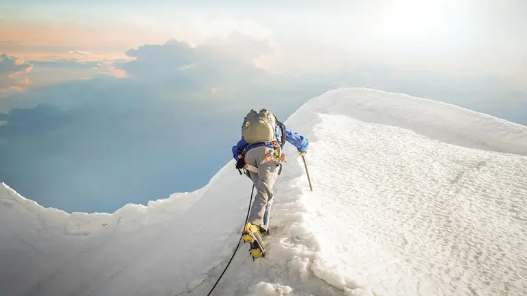 Mann klettert auf einen Berg, Schee