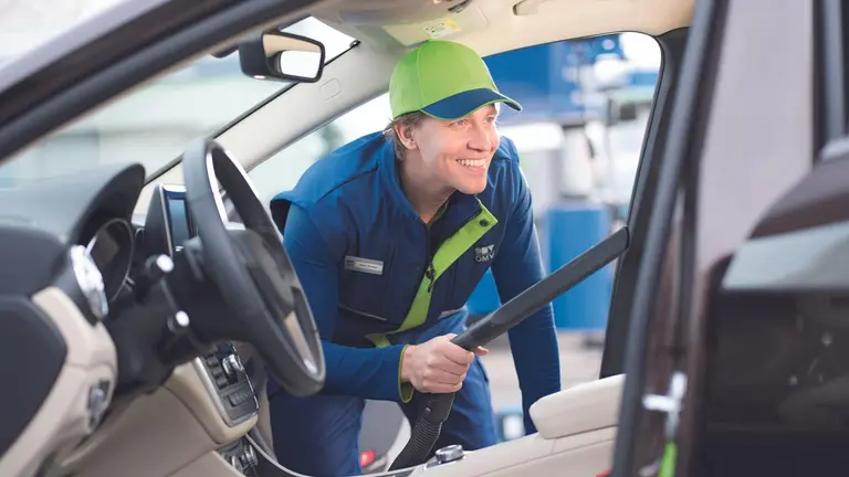 Mitarbeiter von OMV, der ein Auto putzt