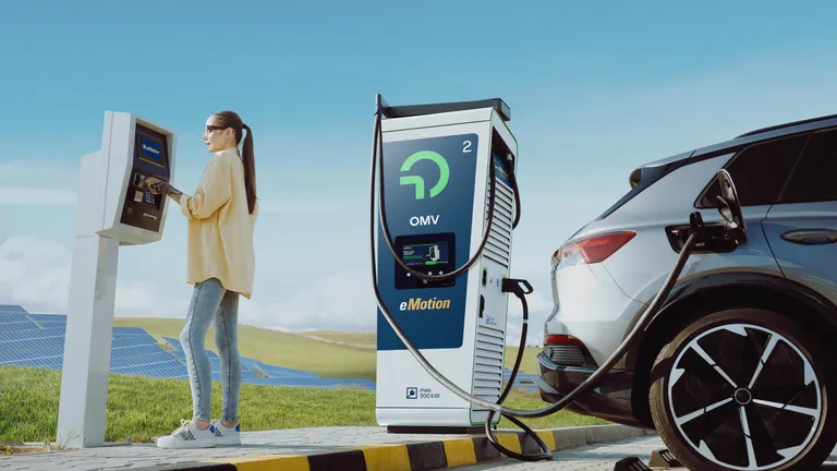A woman at an OMV filling station charging her electric car.