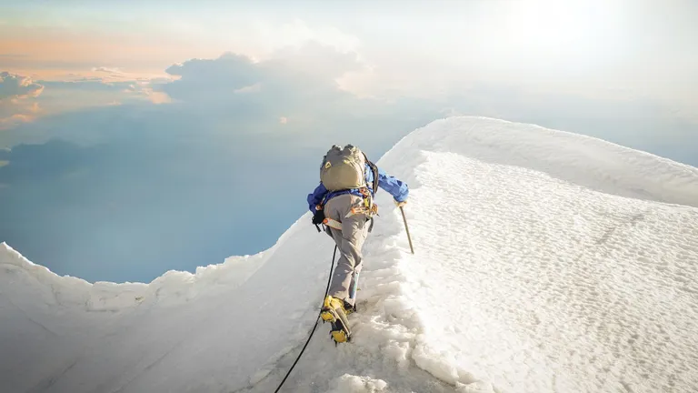 Mann klettert auf einen Berg, Schee