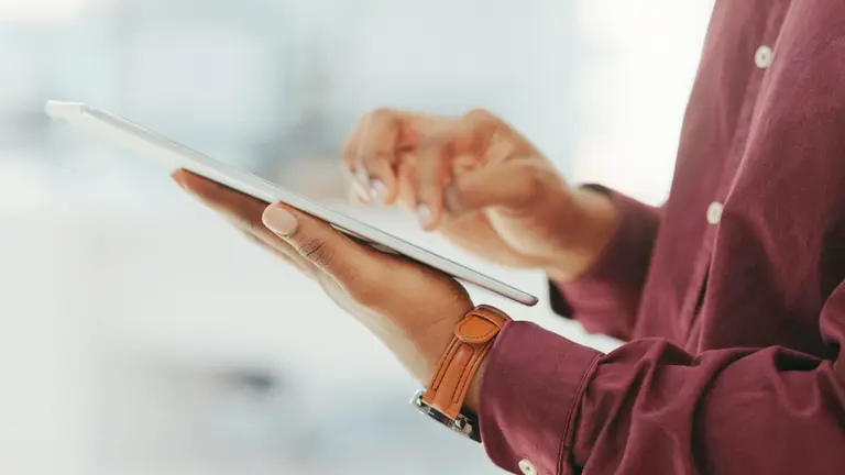 Eine Person die ein Tablet in der Hand hält